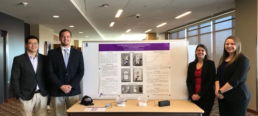 Capstone team presenting their free-space optical stereo communication poster with Dr. Wei.